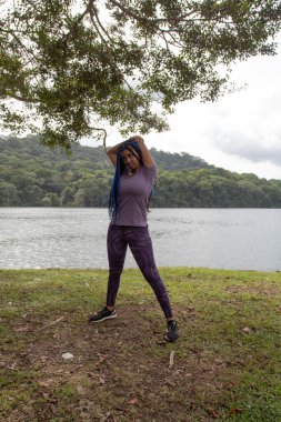 Gölün kıyısında uzanan genç bir afro-soylu kadın.