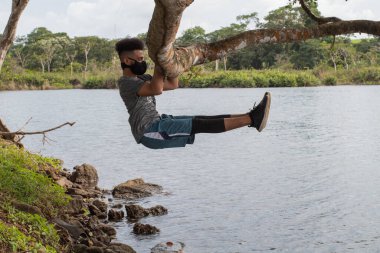 Genç adam doğada jimnastik yapıyor.