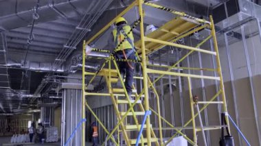 İnşaat işçileri iskele üzerinde çalışıyor.