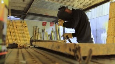 Tezgahta çalışan kaynakçı. Metal kıvılcım kaynaklama ekipmanları.