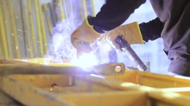 Tezgahta çalışan kaynakçı. Metal kıvılcım kaynaklama ekipmanları.