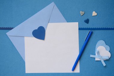 Mavi bir zarf içerisinde ve el ile beyaz boş kağıt kalp el sanatları yaptı