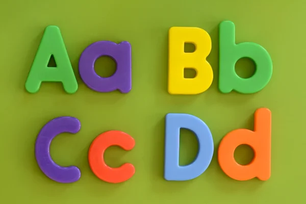 Lettere Aa, Bb, Cc, Dd, in lettere colorate di plastica su sfondo verde — Foto Stock