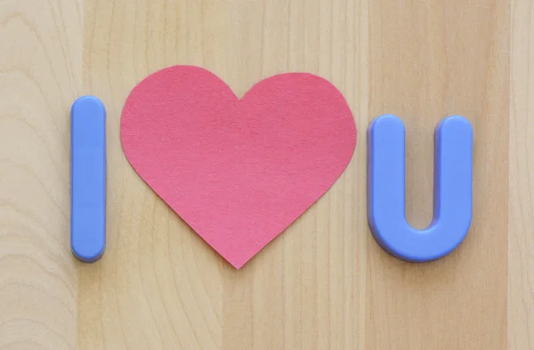 I love U in plastic blue toy letters and flat pink heart shape paper — Stock Photo, Image