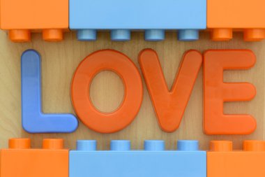 Plastik oyuncak bloklarla çevrili plastik harflerle aşk sözcüğün yakın çekim
