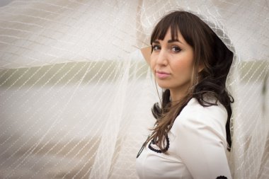 Güzel genç kadın peçe ile bej bir elbise.