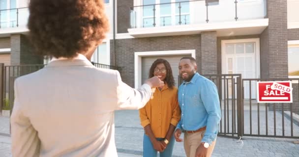 Rear of real-estate selling house to African American happy couple and handing keys. Outdoor. Joyful married man and woman hugging and buying home at outskirt. Getting dwelling in suburb. back view. — Stock Video