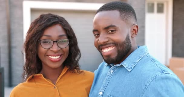 Zblízka šťastný mladý Afroameričan muž a žena s úsměvem na kameru a demonstrující klíč od nového domova. Venku. Kupuje nemovitosti. Pohybuje se v konceptu. Portrét. Rozmazaný. Radostný pár se usazuje. — Stock video