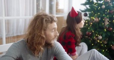 Mutsuz, Kafkasyalı evli çifti, kötü bir ruh halinde, aile kavgasından sonra Noel ağacının yanında otururken yaklaş. Karı koca Noel 'de evde tartıştıktan sonra üzgünler.