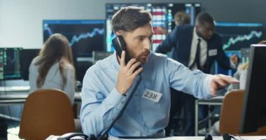 Ticaret ofisinde bilgisayar başında çalışan beyaz tenli yakışıklı bir komisyoncu ve bir çok telefona cevap veriyor. Müşterilerle konuşurken ve borsada çalışırken alım satım yapan tüccarlar..