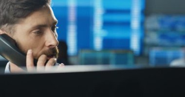 Bilgisayarda çalışan, ticaret bürosunda çalışan ve telefonlara cevap veren Kafkas erkek simsarını kapatın. Müşterilerle konuşurken ve borsada çalışırken alım satım yapan tüccarlar..