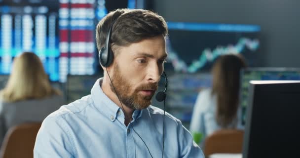 Gros plan de jeune homme blanc beau commerçant dans casque travaillant à l'écran de l'ordinateur dans le bureau de négociation. courtier masculin est contrarié et déçu. J'ai perdu le pari et le taux. Perdre de l'argent sur l'échange. — Video