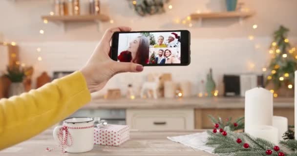 Primo piano dello schermo dello smartphone con più videochiamate online con amici e parenti di razze miste caucasiche in mano femminile a Capodanno a casa. Buon Natale. Ciao. Celebrazione di Natale — Video Stock