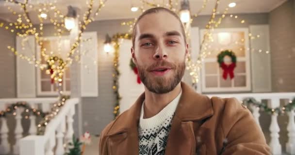 POV de heureux beau jeune homme caucasien debout sur la rue décorée de Noël en ville et vidéo bavardage d'humeur festive envoi de meilleurs voeux sur le Nouvel An. Voeux de Noël Gros plan portrait — Video