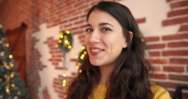 Portreyi kapat. Neşeli, beyaz, güzel bir bayanın görüntülü konferansta gülümsemesi ve konuşması. Dekoratif Xmas odasında keyifli bir ruh hali içinde. Noel tatili konsepti. Yeni Yıl Arifesi