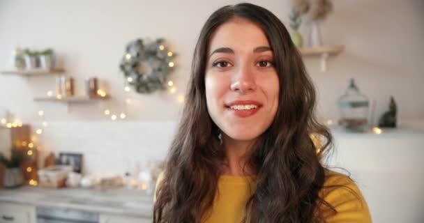 Närbild porträtt. POV av glada kaukasiska vacker ung kvinna talar på videosamtal på internet på gott humör i inredda julrum hemma. Julhelgen koncept. Nyårsafton — Stockvideo