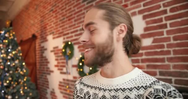 Cierre el retrato. POV de alegre caucásico joven guapo hombre sonriendo y hablando en la videoconferencia en línea de buen humor en decorado sala de Navidad interior. Concepto de vacaciones de Navidad. Nochevieja — Vídeo de stock