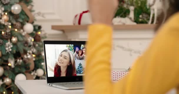 Przez ramię widok ekranu laptopa z wielu połączeń internetowych między różnymi szczęśliwych ludzi mówiących w dobrym nastroju na Boże Narodzenie. Kobieta videochatting na komputerze z krewnymi i przyjaciółmi na Nowy Rok — Wideo stockowe