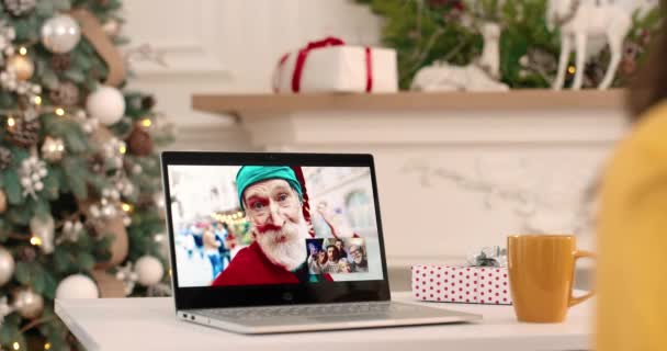 Primo piano dello schermo del computer portatile sul tavolo con più videochiamate tra il vecchio allegro Babbo Natale che parla di Natale con la famiglia felice Diverse persone videochat di Capodanno sul computer Concetto di famiglia — Video Stock