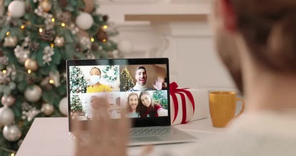 De cerca. Vista por encima del hombro del monitor de la computadora con múltiples videollamadas entre la feliz mujer afroamericana enmascarada, la pareja caucásica y amigos hablando en Año Nuevo en línea. Video chat concepto. — Vídeos de Stock