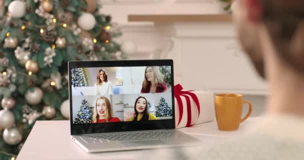 크리스마스에 여러 민족의 여성 친구들과 함께 노트북으로 다중 비디오 통화를 하는 남성의 어깨 너머 모습. 아시아계 백인 행복 한 여성들과 컴퓨터로 비디오를 찍고 있어요. 닫아 — 비디오