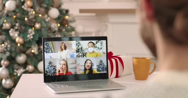 Close up of multiple online call on laptop screen between happy mixed-race female friends speaking on Christmas Eve. Zadní část muže videochatování na Nový rok s různými lidmi. Koncept přátelství — Stock video