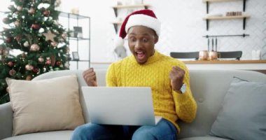 Afro-Amerikalı neşeli sürpriz adam dizüstü bilgisayarından Noel arifesinde piyango kazanma ve mutlu olma hakkında harika haberler alıyor. İnanılmaz bir şans, yeni yıl satışları ve alışveriş. Xmas indirimleri