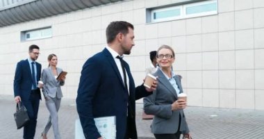 Kafkasyalı bir çift mutlu iş adamı ve iş kadını sabah sokakta yürüyor, konuşuyor ve ellerinde kahve var. Yakışıklı bir adam ve güzel bir kadın işe gitmek için acele ediyorlar..