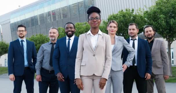 Başarılı Afrikalı Amerikalı kadın patronun portresi. Erkek ve kadın çalışanlardan oluşan bir ekip. Karışık ırk işadamları ve iş kadınları iş merkezinde kameraya gülümsüyor.. — Stok video