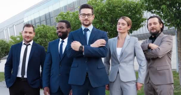 Portret van succesvolle jonge blanke mannelijke baas met een team van multi-etnische mannen en vrouwelijke collega 's. Mixed-races zakenmannen en zakenvrouwen glimlachen naar camera outoors. Gelukkige collega 's. — Stockvideo