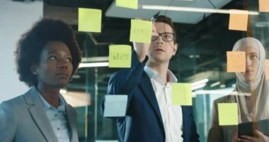 Modern ofiste çalışan melez erkek ve kadın profesyonel işçilere yakın çekim. Dolabın camına kadın iş arkadaşlarıyla konuşurken yakışıklı bir erkek yemliği yazıyormuş. Çalışma konsepti