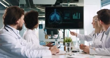 Hastane ofisinde oturan melez doktorlar pulmon hastalığı ve koronavirüs salgını sırasındaki tedavisi hakkında konuşuyorlar. Farklı sağlık görevlileri Covid-19 hakkında toplantı yapıyor. Hastalık konsepti