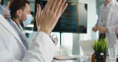 Tıbbi maskeli doktorların el çırpmalarını hastanede oturup Coperid-19 Coronavirus hastalığı tedavisi sunumlarını dinlemelerini istiyorum. Sağlık uzmanları iş başında. Çalışma konsepti