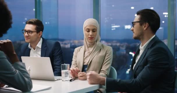 Portrait de jeunes entrepreneurs multi-ethniques assis dans un bureau moderne lors d'une réunion d'équipe et parlant. Homme caucasien discutant d'idées d'affaires avec une femme musulmane lors d'une conférence d'affaires. Concept d'emploi — Video