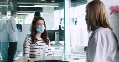 Tıbbi maskeli yaşlı kadın doktorun yakın plan portresi hastanede oturan beyaz kadın hastayla istişare üzerine konuşuyor. Coronavirus konsepti. Covid-19 karantina