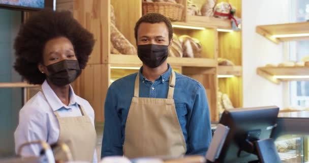 Portré afro-amerikai boldog fiatal házaspár pékek az arcát teszi állva kis saját érdekképviseleti karanténban. Családi ügy. Férfi és nő eladók a kávézóban. Munkahelykoncepció — Stock videók
