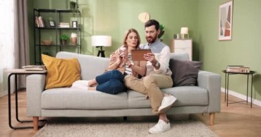 Mutlu, genç, evli, Kafkasyalı bir çift internette geziniyor ve birlikte rahat bir koltukta oturuyorlar. Koca, kahve içen karısıyla konuşan bir alet kullanıyor.