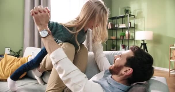 Gros plan de joyeux jeune père adulte jouant avec mignon petit enfant fille caucasienne s'amusant ensemble faire plaine dans l'air. Passer du temps en famille à la maison dans une chambre confortable. Concept de parentalité — Video