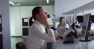 Ciddi, beyaz, güzel, profesyonel laboratuvar uzmanının yan görünüşü laboratuvarda oturup internette bilgisayar sörfü yapıyor. Kadın mikrobiyoloji bilimcisi portresi. Tıp konsepti