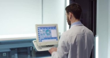 Beyaz önlüklü, beyaz önlüklü, laboratuarda ayakta duran, bilgisayar masaüstüne dokunan, tanı koyan, aşı evrimini inceleyen, yüksek teknoloji araştırmaları yapan, beyaz, genç, meşgul bir doktorun arkası.