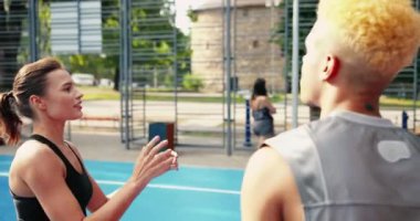 Çok ırklı erkek ve kadın sokak basketbolu çalışmalarının yakın plan portresi. Güzel beyaz kız ve Afrikalı Amerikalı erkek basketbolcular yerel kortta oynuyor. Topu atan kız..