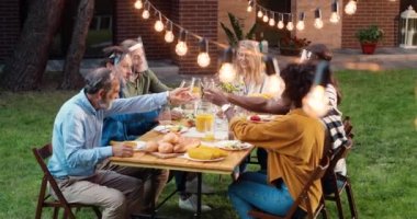 Yüz kalkanları takmış melez insanlar arka bahçede yemek masasında oturup kadeh kaldırıyor ve konuşuyorlar. Çok ırklı bir aile mahkemede piknik yapıyor ve dostça sohbet ediyor. Salgın sırasında iletişim