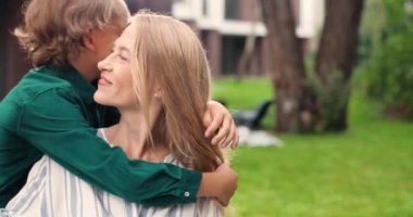 Orta yaşlı, beyaz, sarışın bir kadının portresi. Sevimli, kızıl saçlı, birbirine sarılmış ve kameraya gülümseyen bir oğlu var. Dışarı çıkın. Güzel anne ve küçük çocuk kucaklaşır. Mutlu annelik.