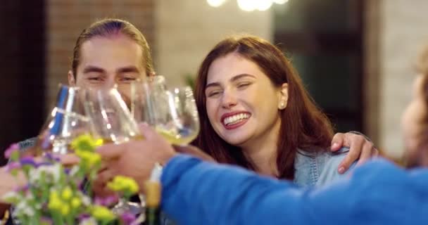 Happy Caucasian vrolijk jong stel lachen en drinken tijdens het toasten en zitten aan feesttafel buiten. Mooie vrouw en knappe man in knuffels tijd doorbrengen met vrienden en plezier hebben. — Stockvideo