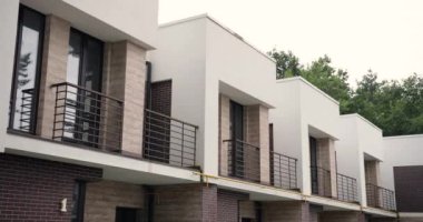 Kırsal kesimde balkonları olan yarı müstakil pahalı evlerin manzarası. Zengin insanların evleri. İpotek, satış konsepti. Banliyöde emlak panoraması. Dışarıdan ikinci kat..