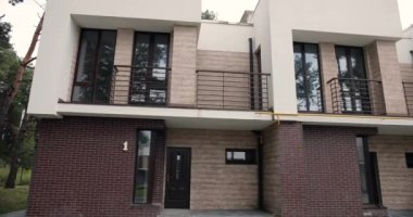 Kırsal kesimde balkonları olan yarı müstakil pahalı evlerin manzarası. Zengin insanların evleri. İpotek, satış konsepti. Banliyöde emlak panoraması. Açık havada..