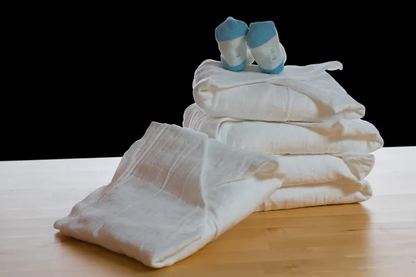 Pilha de fraldas de pano branco quadrado clássico com meias azuis — Fotografia de Stock