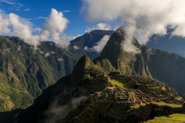 Machu Picchu 'nun İnka tapınağının panoramik manzarası bir grup bulutla çevrili.