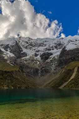 Humantay Gölü 'nün soğuk sularının güzel yeşil ve mavi tonları kutsal Apu Salkantay' ın tabanında yer almaktadır. Güney Amerika, Peru 'da yapılan ünlü yürüyüşte aynı isimle.