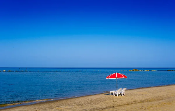 Bich Stühle und Regenschirm an einem verlassenen Strand — Stockfoto